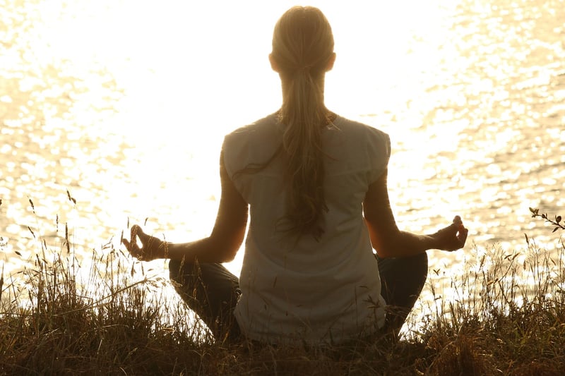 Woman doing yoga at sunset